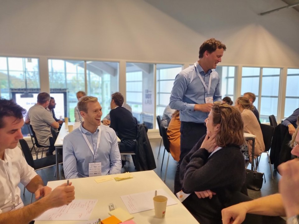 To mennesker ved et bord smiler til hinanden