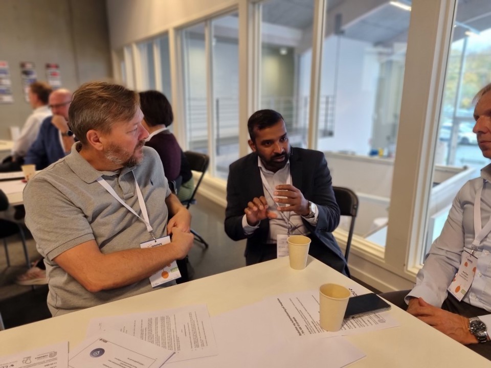 Tre mennesker taler om et bord