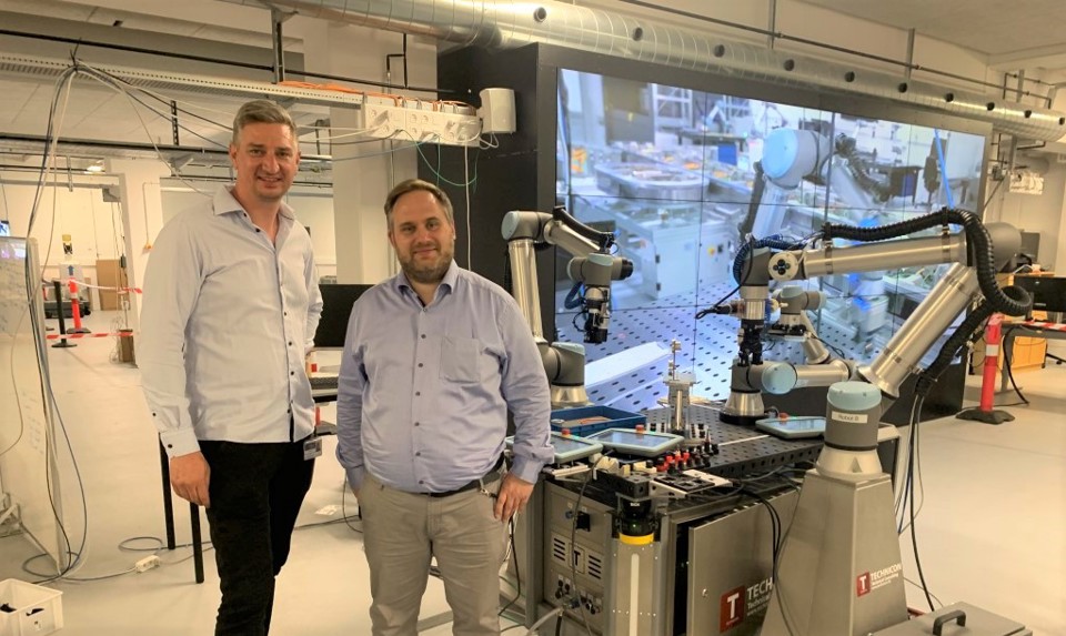 To mænd ved siden af en robot